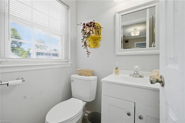 bathroom with healthy amount of natural light, vanity, and toilet