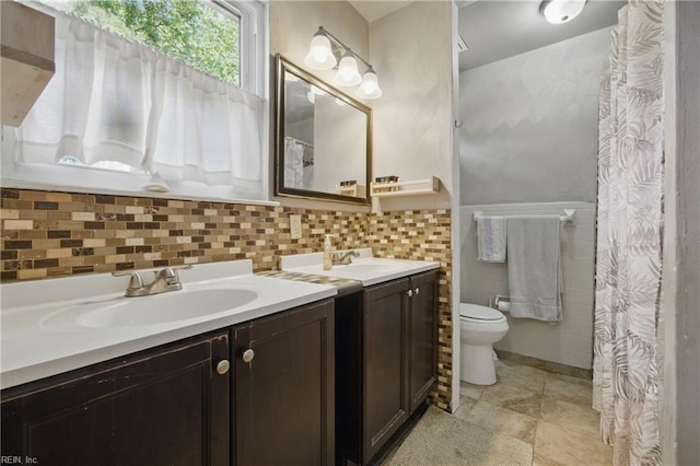 full bath featuring vanity, toilet, and tile walls