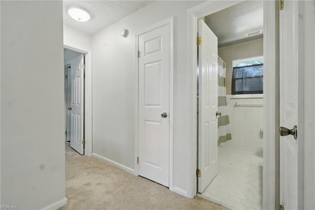 corridor with carpet flooring and baseboards