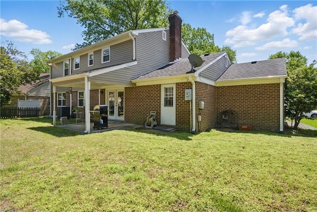 rear view of property featuring brick siding, french doors, a patio area, and a chimney