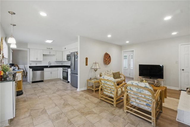 living area featuring recessed lighting and baseboards