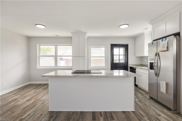 kitchen featuring stainless steel fridge with ice dispenser, white cabinetry, light stone countertops, and a kitchen island