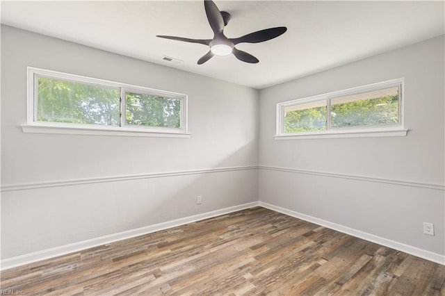 empty room with baseboards, wood finished floors, and ceiling fan