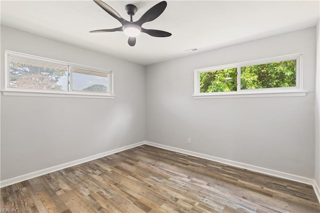 spare room featuring baseboards, wood finished floors, and ceiling fan