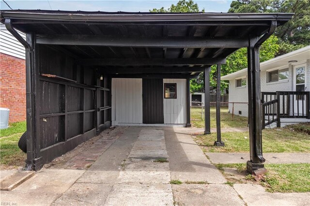 view of outbuilding with fence and concrete driveway