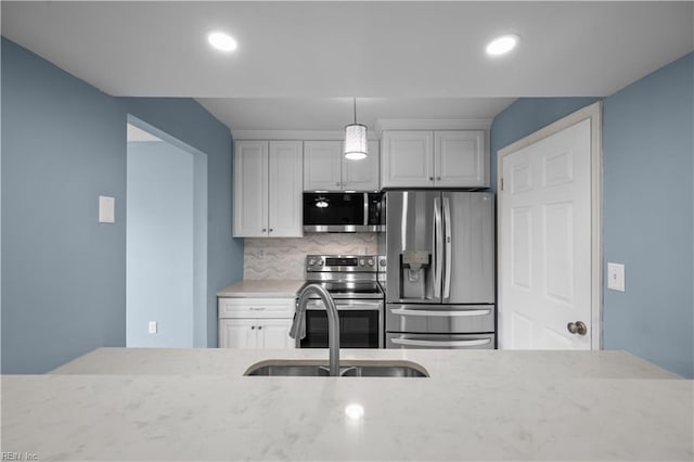 3513 Brigita Ct, Virginia Beach, VA 23453 - kitchen with appliances with stainless steel finishes, a sink, white cabinetry, backsplash, and light stone countertops