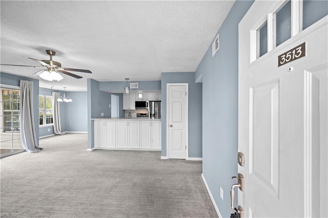3513 Brigita Ct, Virginia Beach, VA 23453 - unfurnished living room featuring baseboards, light colored carpet, a textured ceiling, a ceiling fan, and a chandelier