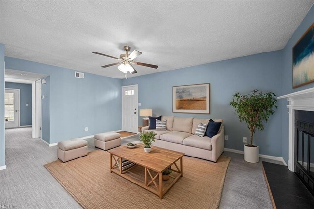 3513 Brigita Ct, Virginia Beach, VA 23453 - carpeted living area featuring a ceiling fan, a textured ceiling, a fireplace with flush hearth, and baseboards