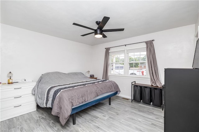 bedroom featuring light wood-type flooring, baseboards, and ceiling fan