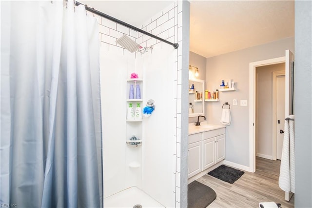 full bathroom with curtained shower, vanity, wood finished floors, and baseboards