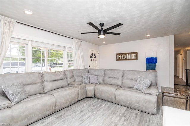 living room featuring wood finished floors, a ceiling fan, recessed lighting, and a textured ceiling