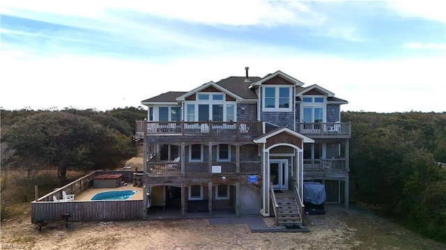 2390 Sandfiddler Rd, Corolla, NC 27927 - view of front facade with a balcony, an outdoor pool, a patio area, and a wooden deck