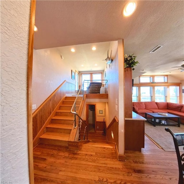 2390 Sandfiddler Rd, Corolla, NC 27927 - stairway with a textured ceiling, a textured wall, a ceiling fan, hardwood / wood-style flooring, and vaulted ceiling