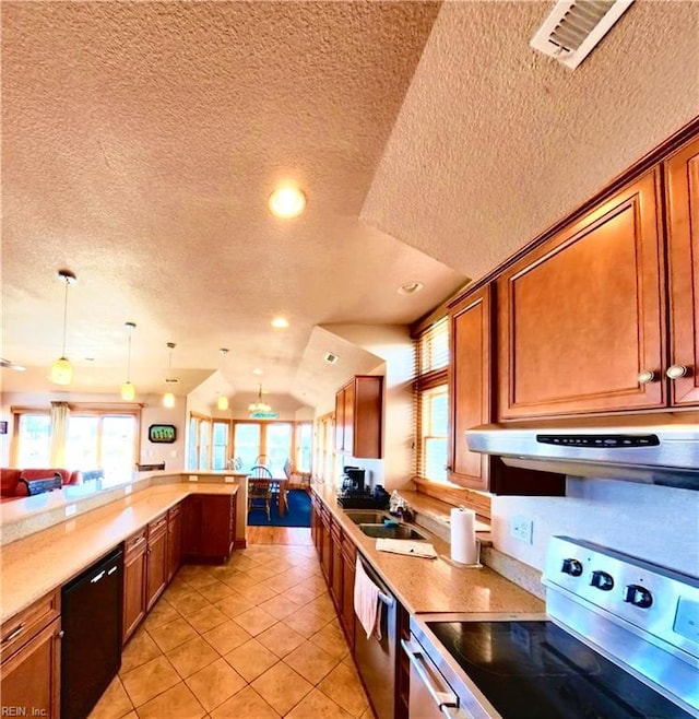 2390 Sandfiddler Rd, Corolla, NC 27927 - kitchen with stainless steel appliances, range hood, a textured ceiling, brown cabinetry, and recessed lighting
