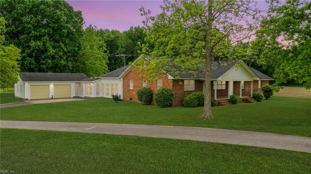 138 Howells Ln, Hertford, NC 27944 - ranch-style home with a porch, a front yard, a garage, and brick siding