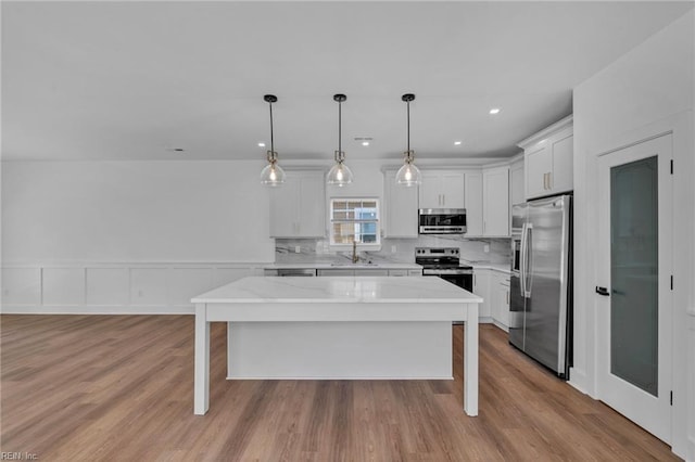 1 Lacrosse St, Hampton, VA 23663 - kitchen with stainless steel appliances, a sink, a center island, white cabinetry, and backsplash