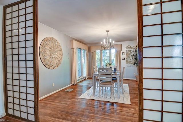2029 Heron Ct, Suffolk, VA 23433 - dining space featuring wood finished floors, a chandelier, and baseboards