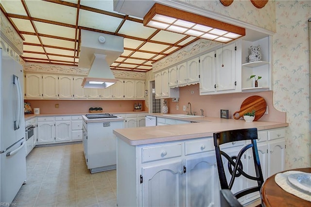 2029 Heron Ct, Suffolk, VA 23433 - kitchen featuring wallpapered walls, a sink, a peninsula, white appliances, and light countertops