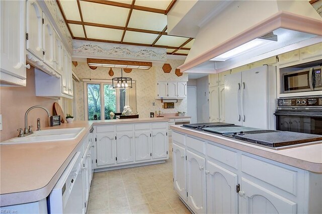 2029 Heron Ct, Suffolk, VA 23433 - kitchen featuring white appliances, a sink, white cabinets, wallpapered walls, and light countertops