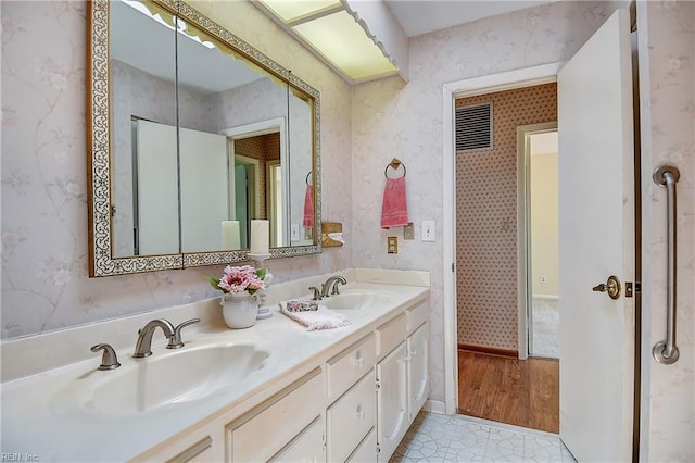 2029 Heron Ct, Suffolk, VA 23433 - full bathroom featuring wallpapered walls, double vanity, baseboards, and wood finished floors