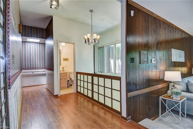 2029 Heron Ct, Suffolk, VA 23433 - corridor featuring wallpapered walls, wood finished floors, a chandelier, and a wainscoted wall