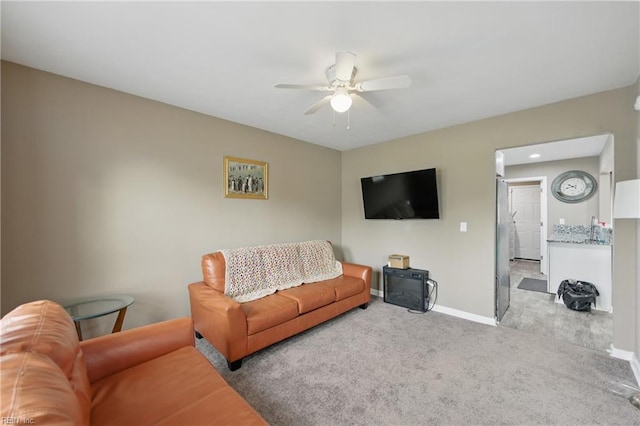 carpeted living room featuring ceiling fan and baseboards