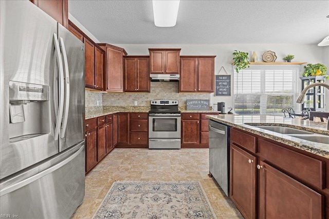 254 Mcpherson Rd, South Mills, NC 27976 - kitchen featuring stainless steel appliances, a sink, under cabinet range hood, light stone countertops, and decorative backsplash
