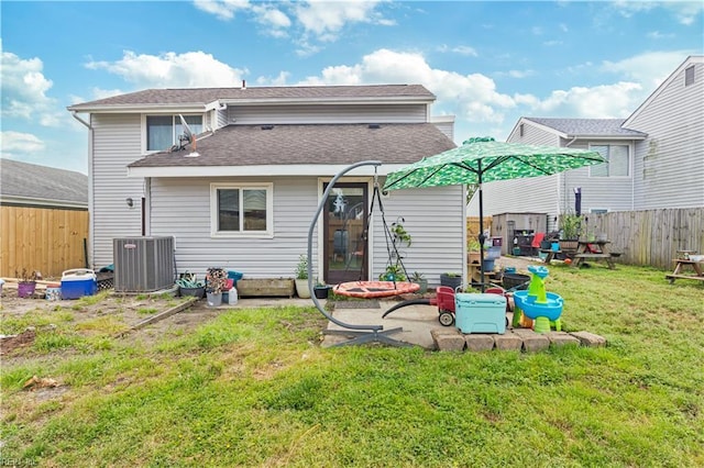 rear view of property featuring central AC unit and a shingled roof