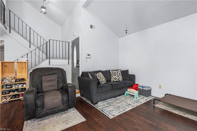 living room with wood finished floors, stairway, high vaulted ceiling, and baseboards