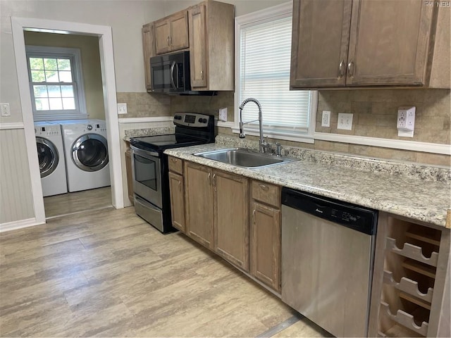 220 Chesterfield Rd, Hampton, VA 23661 - kitchen featuring appliances with stainless steel finishes, a sink, washing machine and dryer, light wood-style floors, and tasteful backsplash