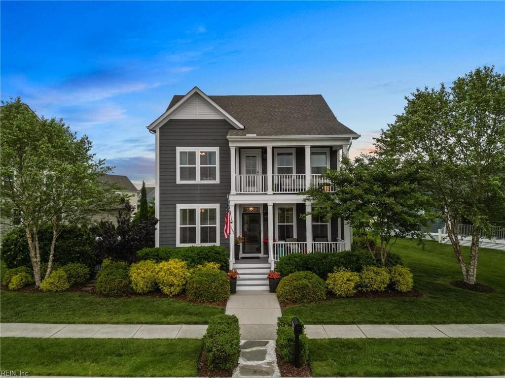 3332 Patrick Henry Dr, Chesapeake, VA 23323 - view of front of home featuring a balcony, covered porch, a front yard, and a shingled roof