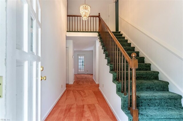 205 Shackleford Rd, Yorktown, VA 23693 - staircase featuring a chandelier, baseboards, carpet flooring, and a towering ceiling
