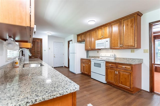 205 Shackleford Rd, Yorktown, VA 23693 - kitchen with white appliances, a sink, brown cabinets, dark wood-style flooring, and light stone counters
