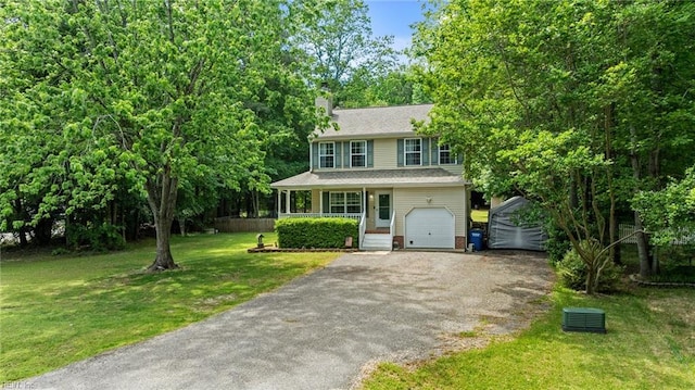 view of front of house with asphalt driveway, a chimney, a front yard, a garage, and covered porch