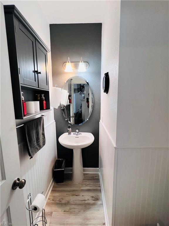 bathroom featuring wood finished floors and a wainscoted wall