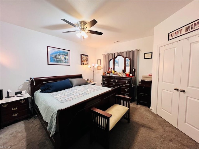 bedroom featuring dark colored carpet, a closet, and a ceiling fan