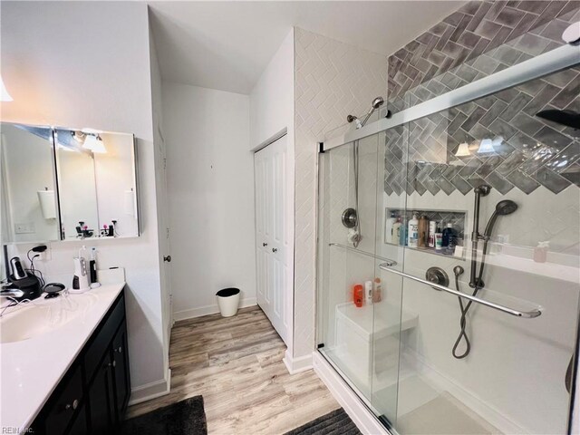 bathroom with a shower stall, wood finished floors, and vanity
