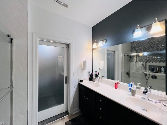 bathroom featuring a shower stall and double vanity