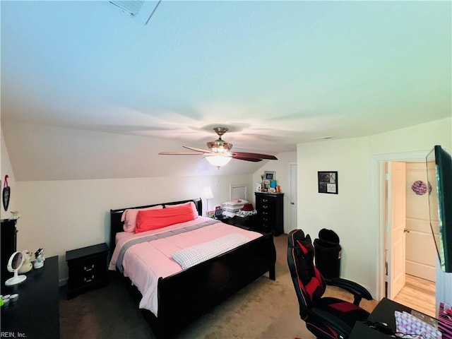 bedroom featuring vaulted ceiling, light carpet, and a ceiling fan