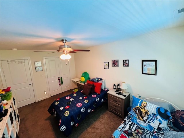 bedroom featuring dark carpet, a ceiling fan, and a closet