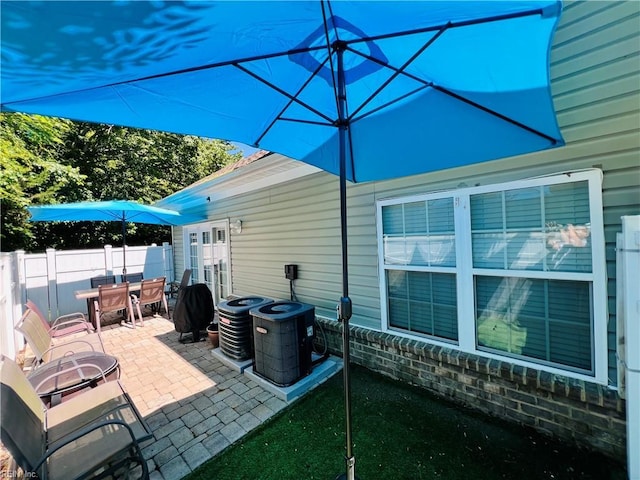 view of patio / terrace featuring outdoor dining area, fence, and central AC