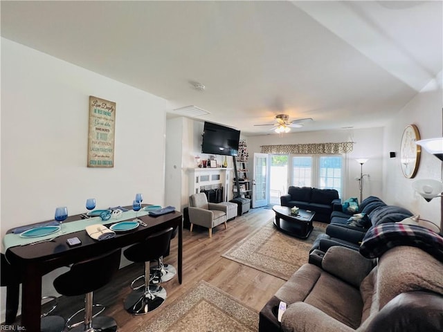 living area with light wood-type flooring and a ceiling fan