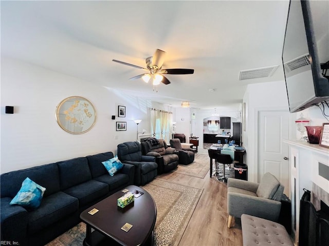 living room with light wood finished floors and a ceiling fan