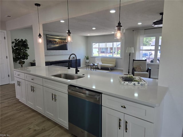 kitchen featuring stainless steel dishwasher, a sink, dark wood finished floors, recessed lighting, and healthy amount of natural light