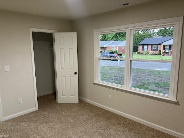 unfurnished bedroom featuring carpet flooring, baseboards, a spacious closet, and a closet