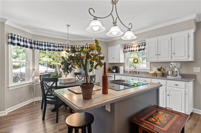 kitchen with black electric cooktop, a breakfast bar, white cabinets, dark wood finished floors, and light countertops