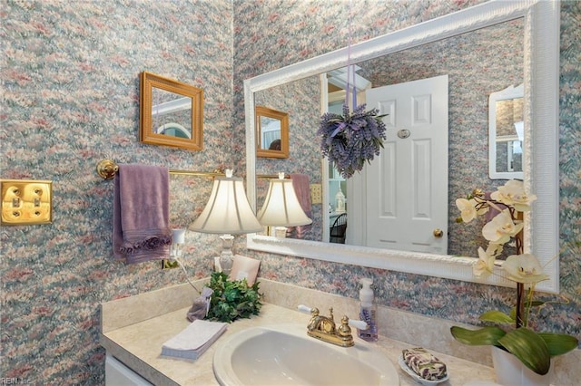 bathroom with wallpapered walls and vanity