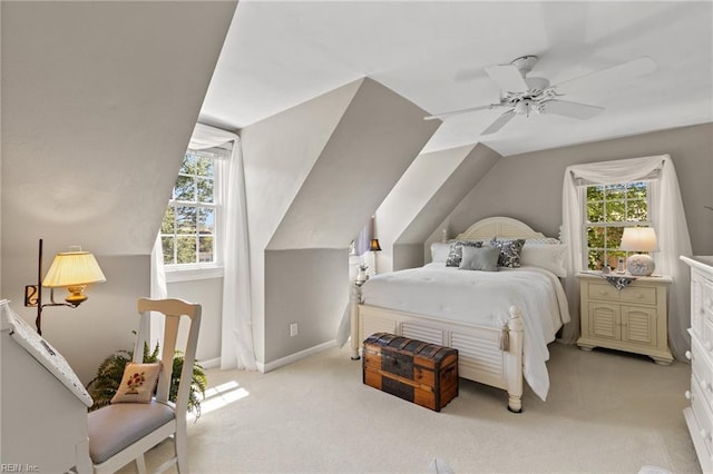 bedroom featuring multiple windows, light colored carpet, ceiling fan, baseboards, and vaulted ceiling