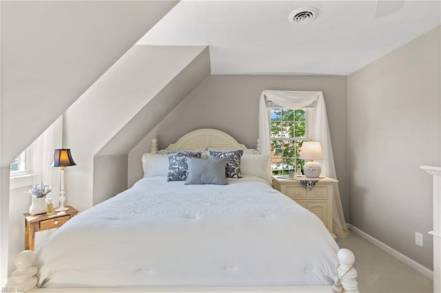 bedroom with light colored carpet, vaulted ceiling, and baseboards