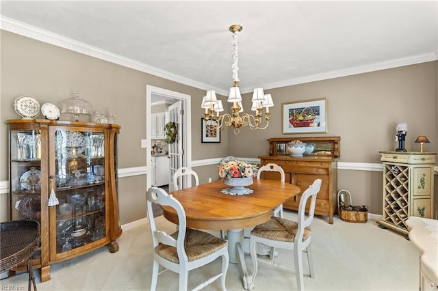 dining area with light carpet, a chandelier, ornamental molding, and baseboards